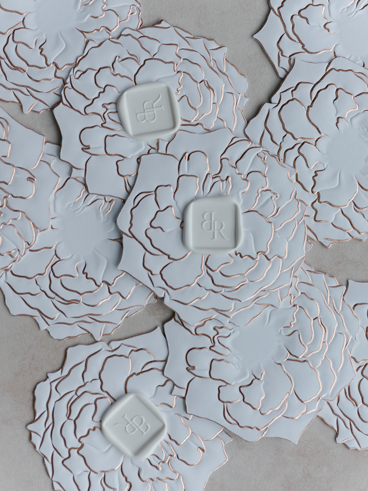 Decorative white paper flowers with intricate patterns on a gray background