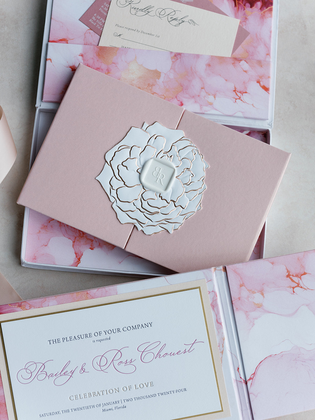 Pink wedding invitation with floral design on a watercolor background