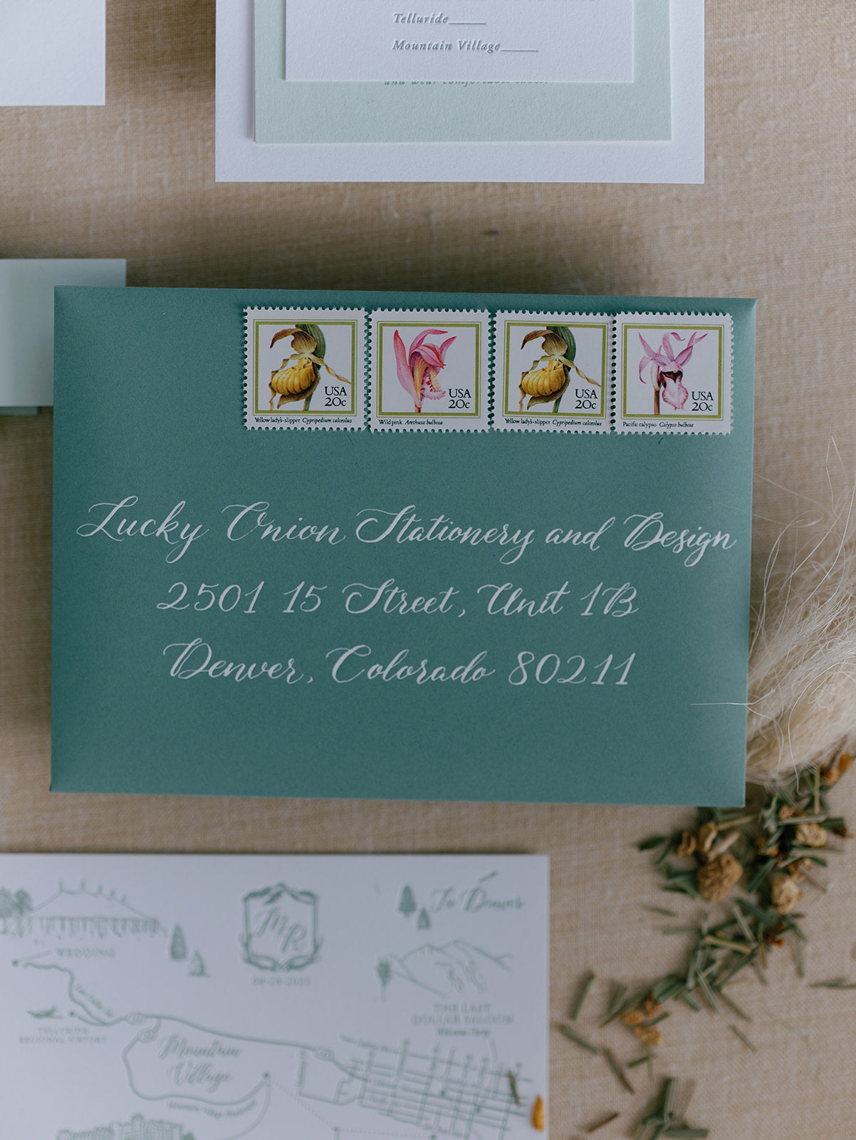 Green envelope with stamps and address on a textured surface