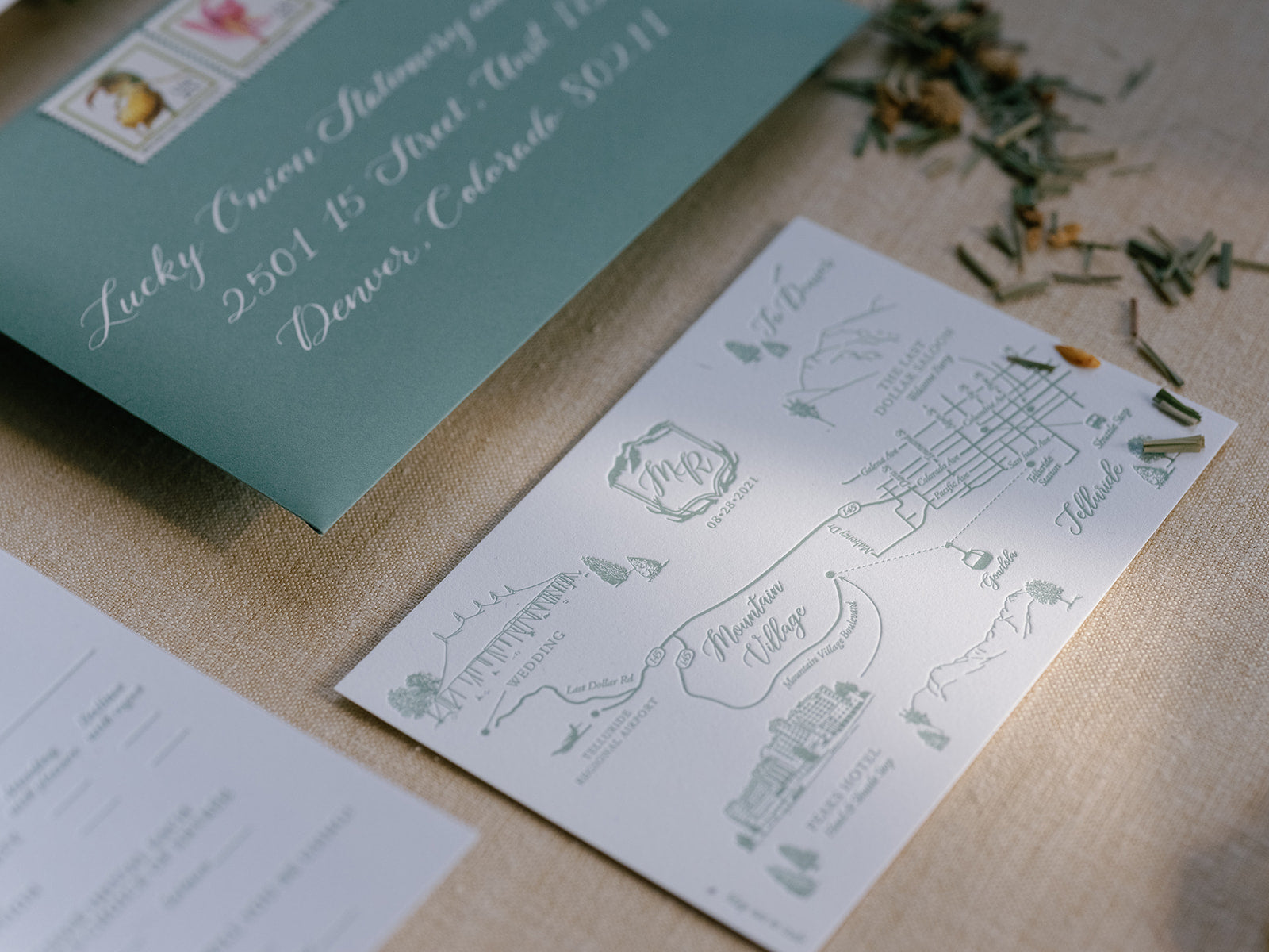 Map and invitation card on a textured surface with decorative elements.